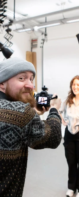 Student photographer capturing a portrait in a professional studio setup with lighting equipment. Student photographer capturing a portrait in a professional studio setup with lighting equipment.